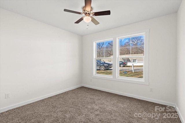 empty room with ceiling fan, carpet, and baseboards