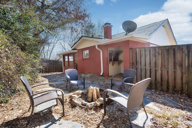 exterior space with a patio, fence, a chimney, and stucco siding