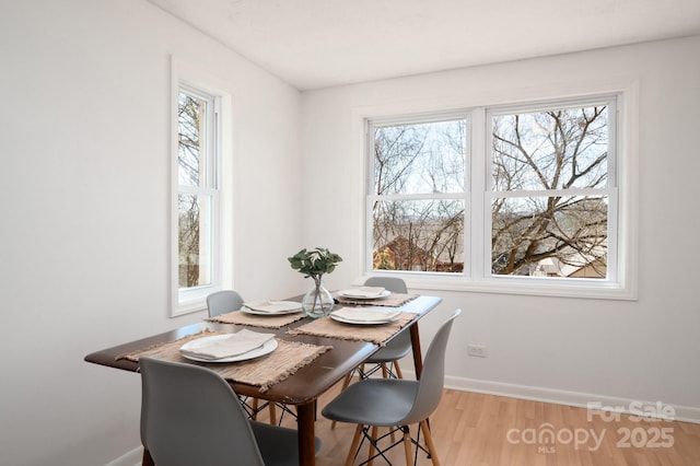 dining space with baseboards and wood finished floors