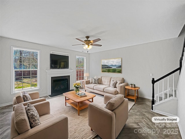 living room featuring ceiling fan and dark parquet floors