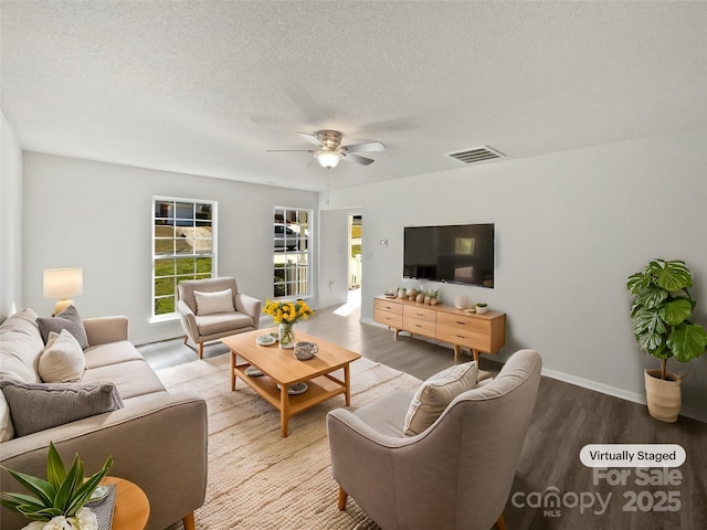 living room featuring visible vents, a ceiling fan, a textured ceiling, wood finished floors, and baseboards