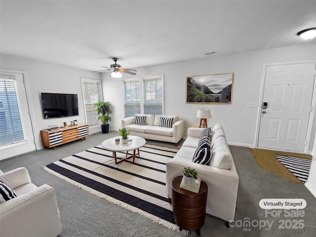 living room with ceiling fan and dark colored carpet