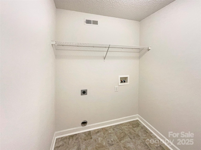 clothes washing area featuring hookup for a washing machine, hookup for an electric dryer, and a textured ceiling