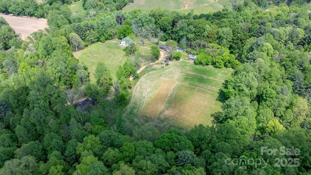 birds eye view of property featuring a rural view and a wooded view
