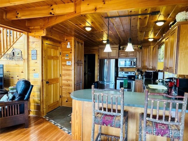 202 Panorama Dr, Nebo, NC 28761 - kitchen featuring appliances with stainless steel finishes, wooden ceiling, a peninsula, hardwood / wood-style floors, and wooden walls
