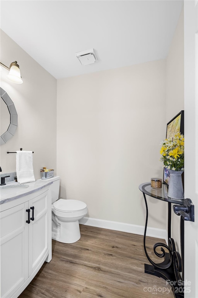 1133 Bloom Wood Ln, Matthews, NC 28105 - half bathroom featuring toilet, visible vents, baseboards, wood finished floors, and vanity