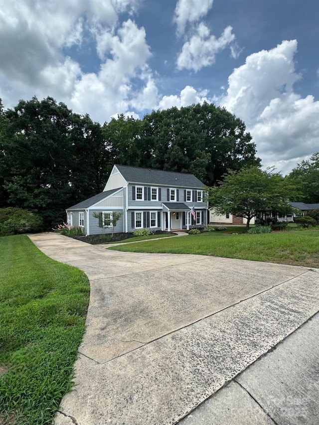 1133 Bloom Wood Ln, Matthews, NC 28105 - colonial home with covered porch, a front lawn, and driveway