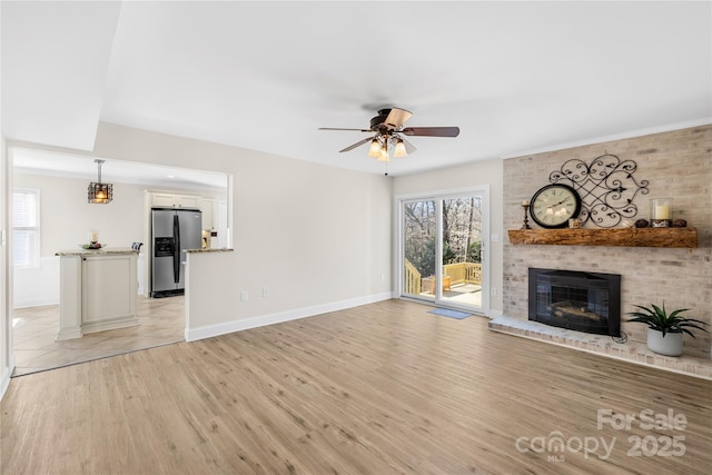 1133 Bloom Wood Ln, Matthews, NC 28105 - unfurnished living room with a ceiling fan, a fireplace, and light wood-type flooring