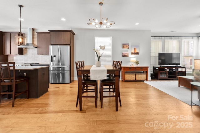 dining room with a chandelier, recessed lighting, a healthy amount of sunlight, and light wood-style flooring