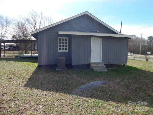 view of outdoor structure featuring a yard, a carport, and cooling unit