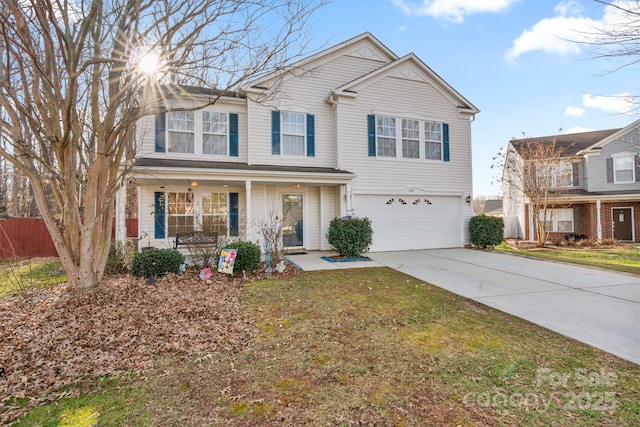 view of front of house featuring a garage, covered porch, and a front yard