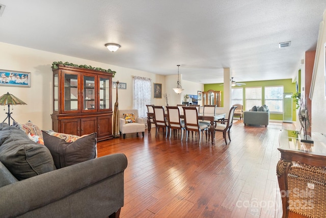 dining area featuring a textured ceiling, dark wood-type flooring, and ceiling fan