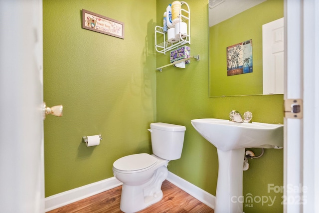 bathroom featuring wood-type flooring and toilet