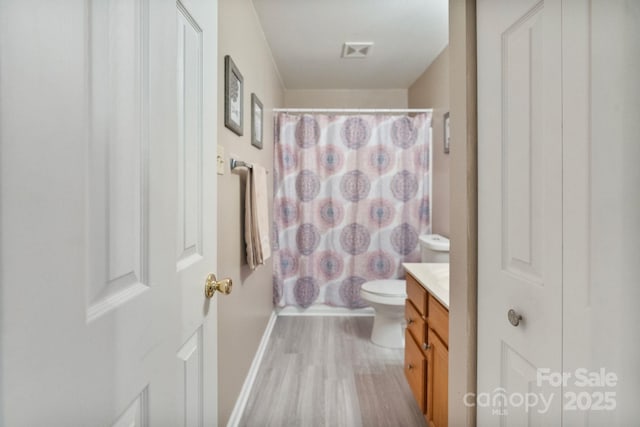 full bathroom featuring toilet, hardwood / wood-style flooring, vanity, and shower / tub combo