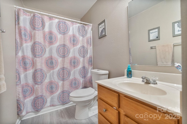 bathroom with hardwood / wood-style flooring, toilet, and vanity