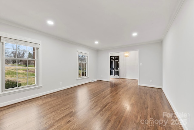 spare room featuring crown molding, recessed lighting, wood finished floors, and baseboards