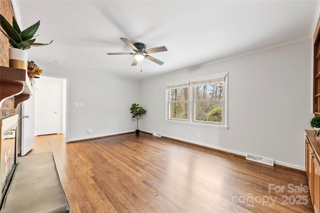 unfurnished living room with light wood-style flooring, crown molding, visible vents, baseboards, and ceiling fan