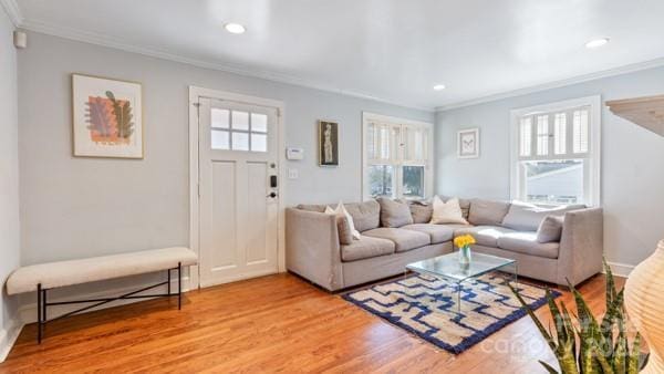 living area with recessed lighting, light wood-style floors, and ornamental molding