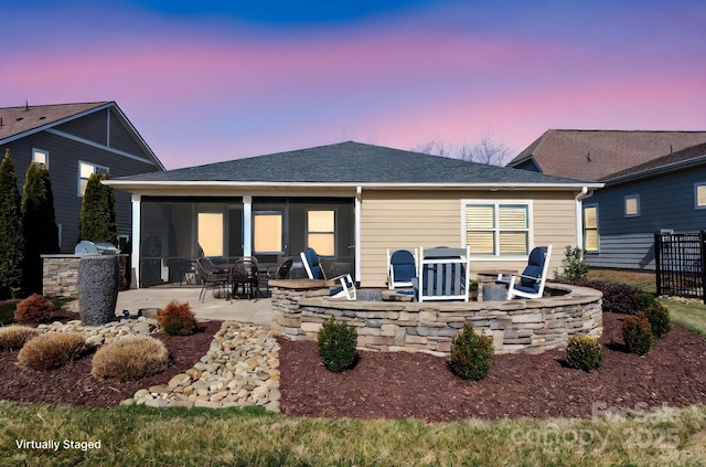 rear view of house with roof with shingles, a patio, an outdoor kitchen, a sunroom, and fence