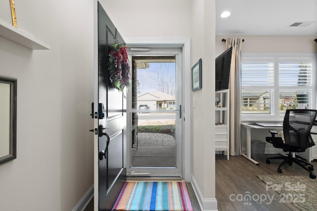 foyer entrance featuring baseboards, wood finished floors, visible vents, and a healthy amount of sunlight