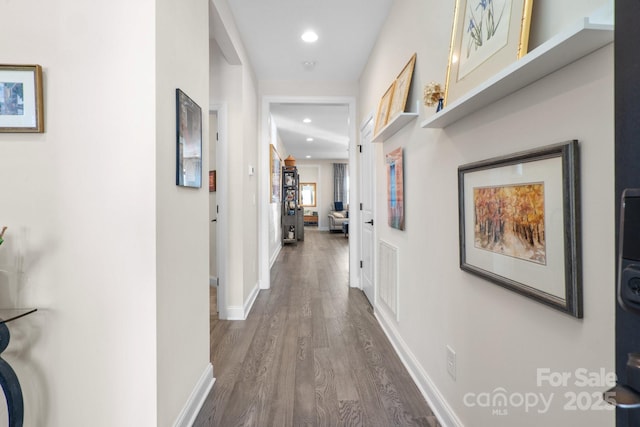 hall featuring visible vents, baseboards, dark wood-style flooring, and recessed lighting