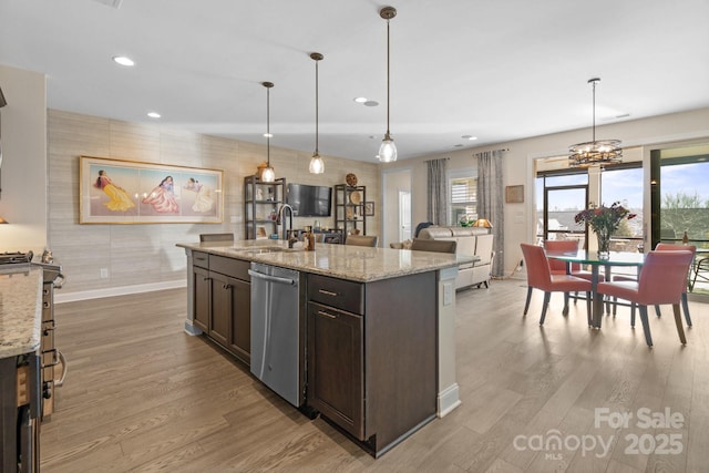 kitchen with plenty of natural light, dishwasher, a sink, and wood finished floors