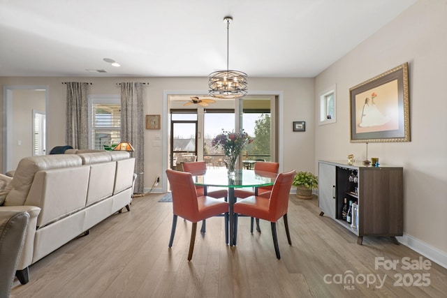 dining room featuring light wood-type flooring, visible vents, a notable chandelier, and baseboards