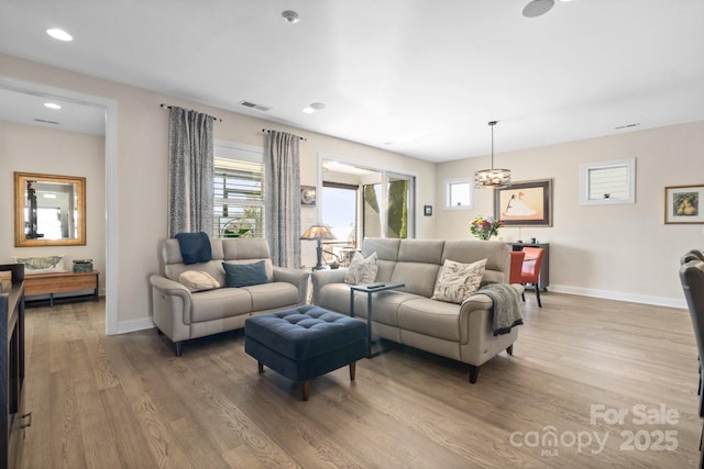 living area with recessed lighting, wood finished floors, visible vents, and baseboards