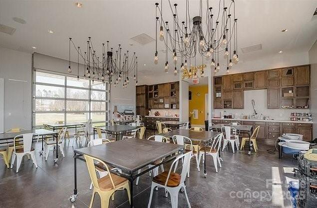 dining space featuring a high ceiling and finished concrete floors