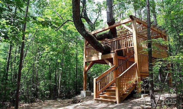 view of play area featuring stairway and a view of trees