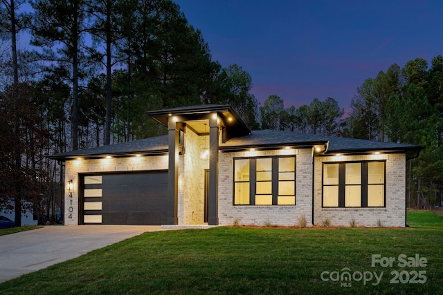 view of front of home with a garage and a yard