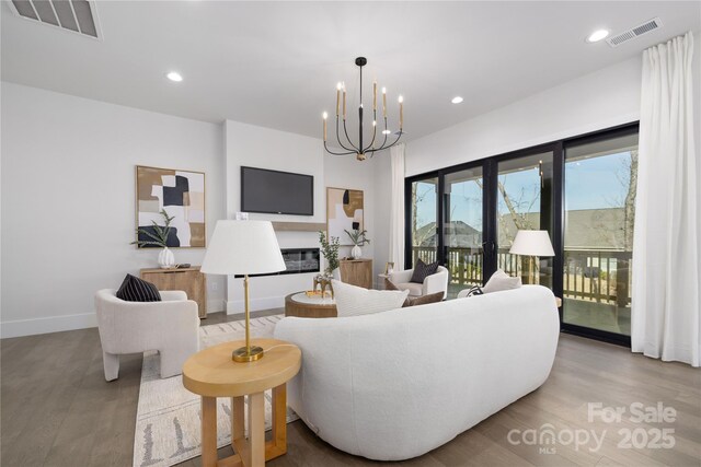 17201 Green Hill Rd, Charlotte, NC 28278 - living room with an inviting chandelier, wood finished floors, visible vents, and baseboards