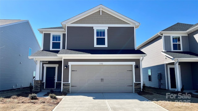 view of front of home featuring an attached garage, stone siding, a shingled roof, and concrete driveway