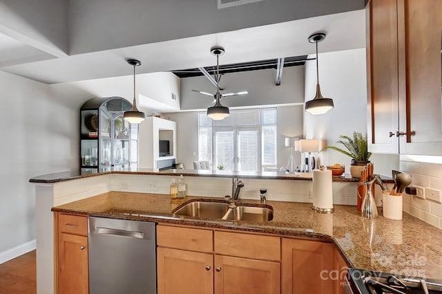 kitchen with tasteful backsplash, dark stone counters, dishwasher, decorative light fixtures, and a sink