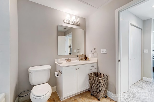 full bath featuring toilet, vanity, and baseboards