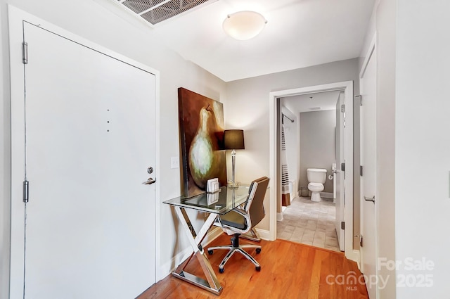 office with visible vents, baseboards, and wood finished floors