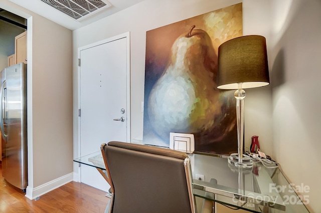 office area with baseboards, visible vents, and light wood finished floors