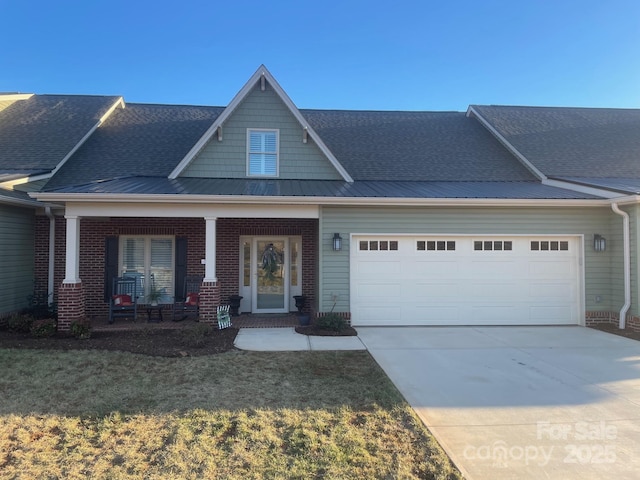 view of front of home featuring a garage, a front lawn, and a porch