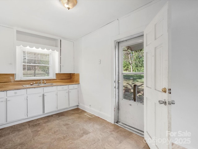 kitchen featuring sink and white cabinetry