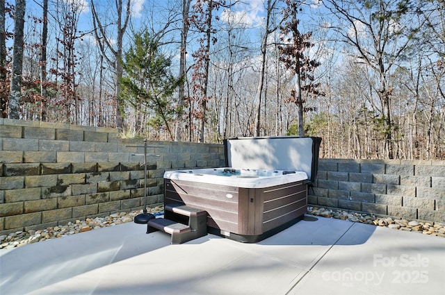 exterior space with a hot tub and fence