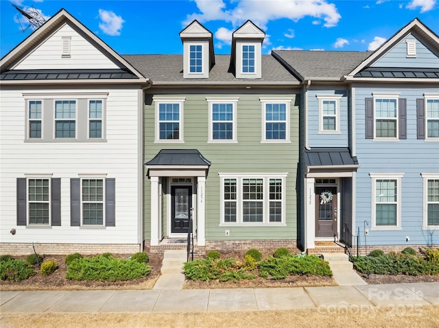 townhome / multi-family property featuring a standing seam roof, metal roof, and roof with shingles