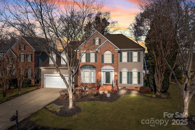 colonial home with a lawn and a garage