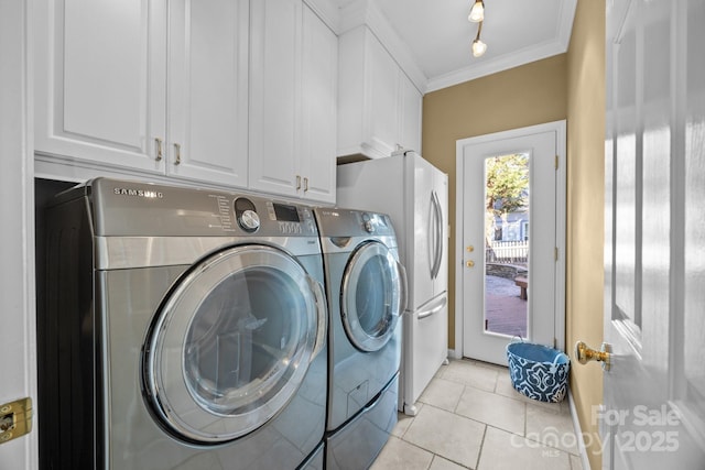 laundry room featuring cabinets, washer and dryer, light tile patterned floors, and crown molding