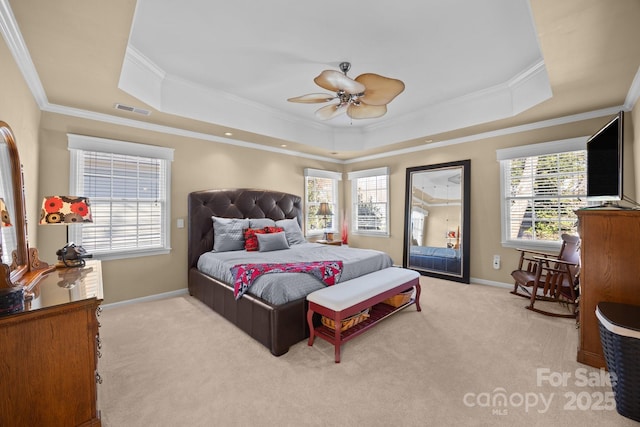 bedroom featuring a tray ceiling, crown molding, light colored carpet, and ceiling fan