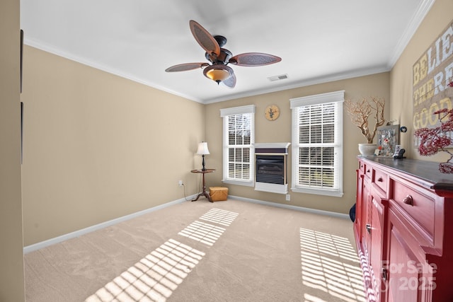 interior space with ceiling fan, crown molding, and light colored carpet