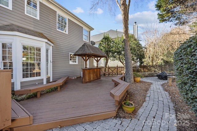 wooden terrace featuring a gazebo and a fire pit