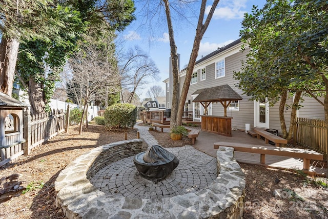 view of yard featuring a deck and an outdoor fire pit