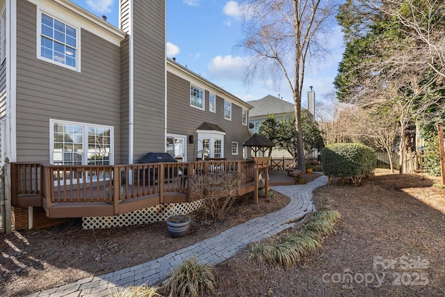 rear view of house with a wooden deck and a gazebo