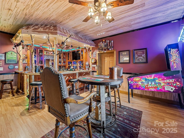 dining room with wainscoting, a dry bar, wooden ceiling, and wood finished floors