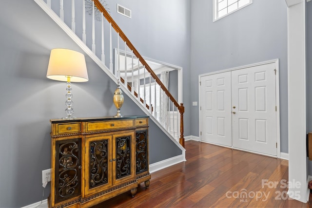 entrance foyer featuring dark hardwood / wood-style floors and a towering ceiling